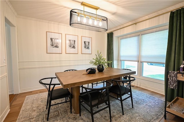 17586 W 112th St, Olathe, KS 66061 - dining space featuring crown molding, a chandelier, baseboards, and wood finished floors