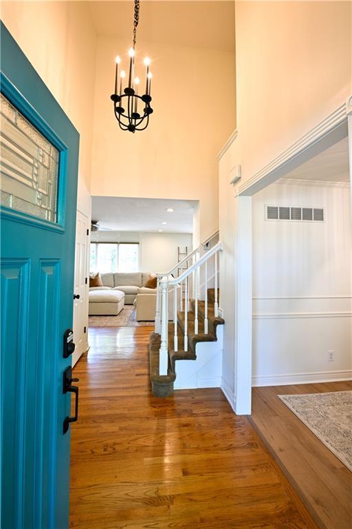 17586 W 112th St, Olathe, KS 66061 - entrance foyer with a towering ceiling, a chandelier, stairs, wood finished floors, and baseboards