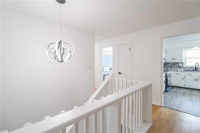 956 Ridge Dr, Warrensburg, MO 64093 - corridor featuring a chandelier, light wood finished floors, and a sink