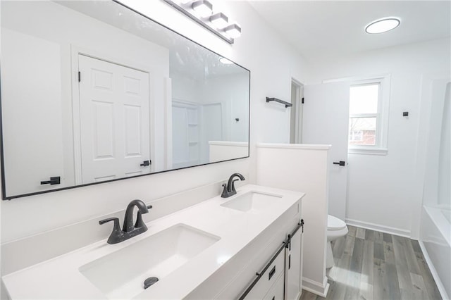 956 Ridge Dr, Warrensburg, MO 64093 - full bathroom with double vanity, toilet, and wood finished floors