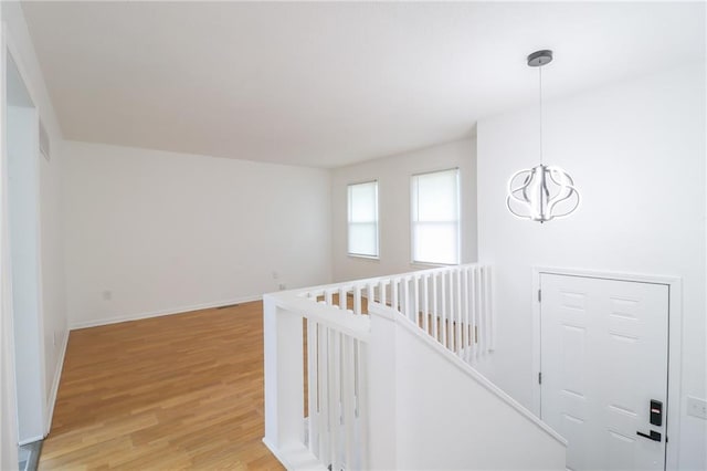 956 Ridge Dr, Warrensburg, MO 64093 - hall with light wood-style floors, an upstairs landing, a chandelier, and baseboards