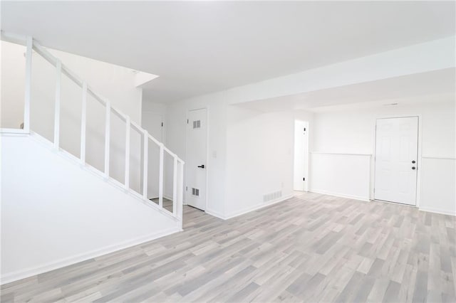 956 Ridge Dr, Warrensburg, MO 64093 - unfurnished living room with stairs, light wood-type flooring, and baseboards