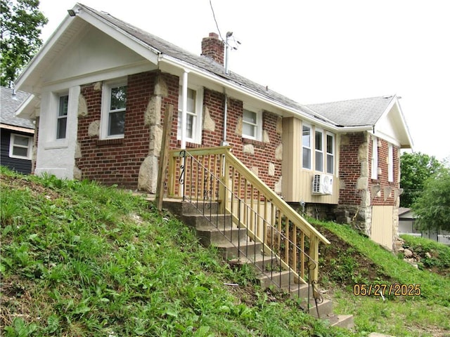2119 N 32nd St Unit K, Kansas City, KS 66104 - view of front of house featuring a chimney, brick siding, a shingled roof, and ac unit