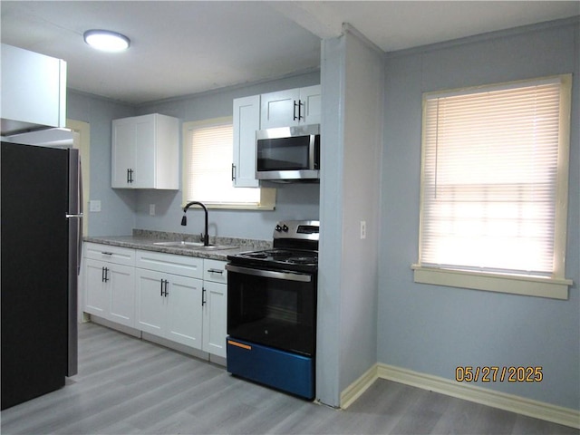 2119 N 32nd St Unit K, Kansas City, KS 66104 - kitchen with stainless steel appliances, a sink, light wood-type flooring, and white cabinets