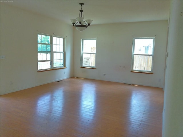 503 W Shawnee St, Paola, KS 66071 - unfurnished room featuring a chandelier, light wood-style floors, and baseboards