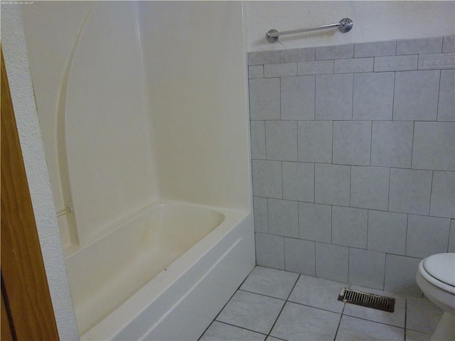 503 W Shawnee St, Paola, KS 66071 - bathroom with tile patterned floors, toilet, tile walls, and shower / washtub combination