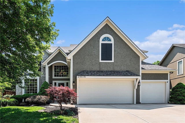21605 W 98th Ter, Lenexa, KS 66220 - traditional-style house with concrete driveway, stucco siding, and a garage