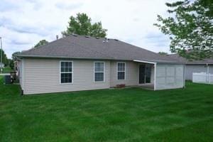814 Clancy Ct, Raymore, MO 64083 - rear view of house with a yard