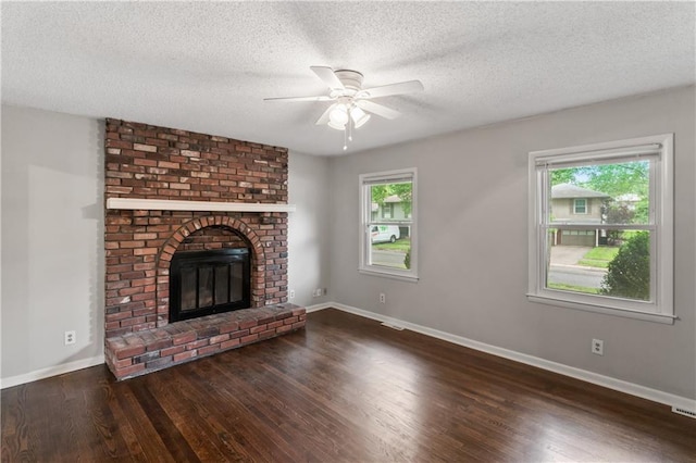 6401 E 120th Ter, Grandview, MO 64030 - unfurnished living room featuring wood finished floors, ceiling fan, baseboards, a textured ceiling, and a fireplace