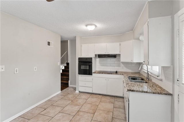 6401 E 120th Ter, Grandview, MO 64030 - kitchen featuring black appliances, a sink, under cabinet range hood, tasteful backsplash, and a textured ceiling