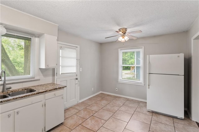 6401 E 120th Ter, Grandview, MO 64030 - kitchen featuring freestanding refrigerator, a sink, white cabinetry, ceiling fan, and a textured ceiling