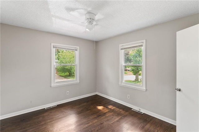 6401 E 120th Ter, Grandview, MO 64030 - empty room with healthy amount of natural light, a ceiling fan, dark wood-type flooring, baseboards, and a textured ceiling