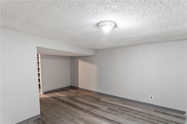 6401 E 120th Ter, Grandview, MO 64030 - finished below grade area with a textured ceiling, wood finished floors, and baseboards