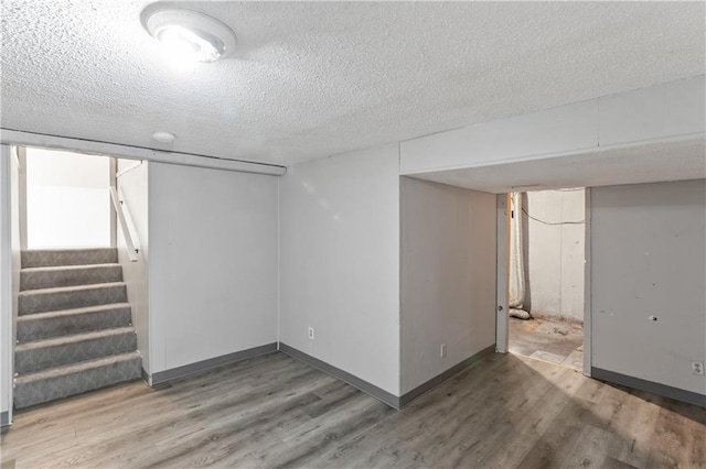 6401 E 120th Ter, Grandview, MO 64030 - finished below grade area with wood finished floors, stairs, a textured ceiling, and baseboards