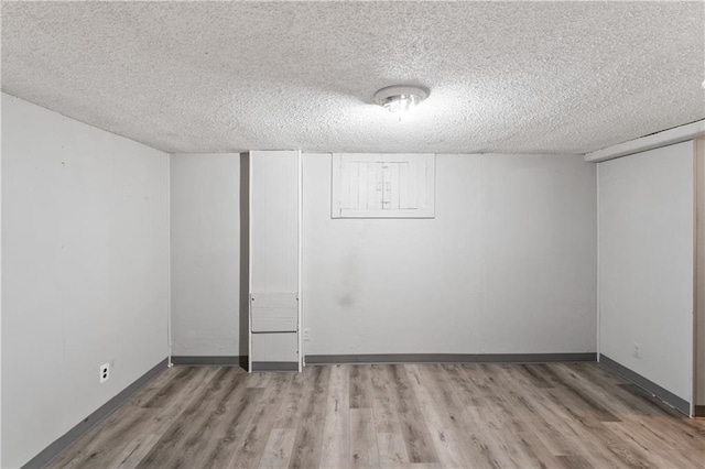 6401 E 120th Ter, Grandview, MO 64030 - finished below grade area with wood finished floors, a textured ceiling, and baseboards