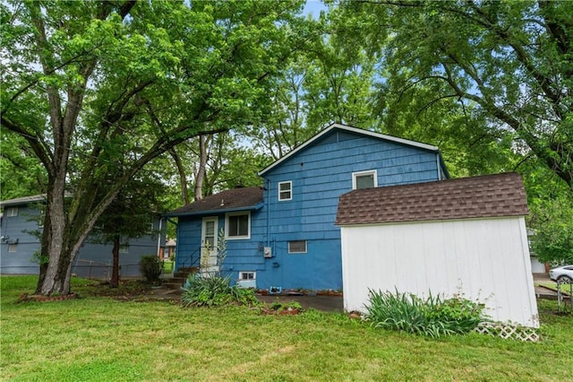 6401 E 120th Ter, Grandview, MO 64030 - rear view of house with roof with shingles and a lawn