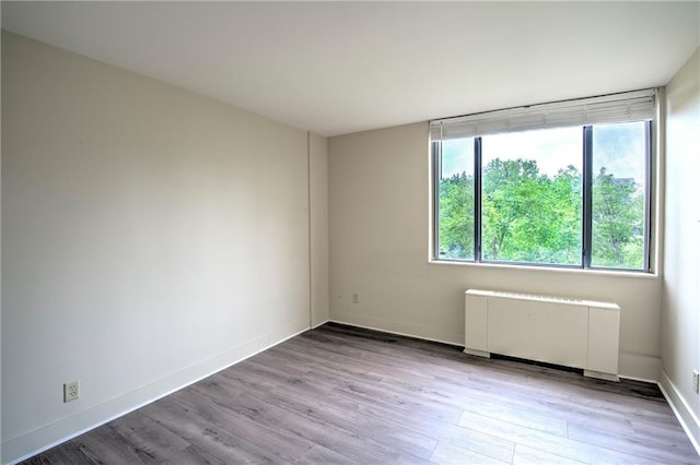 600 E 8th St Unit 5N, Kansas City, MO 64106 - spare room featuring radiator heating unit, wood finished floors, and baseboards