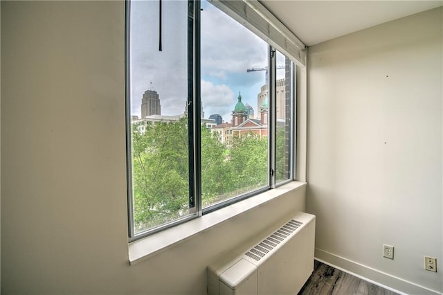 600 E 8th St Unit 5N, Kansas City, MO 64106 - detailed view of wood finished floors, baseboards, a view of city, and radiator heating unit