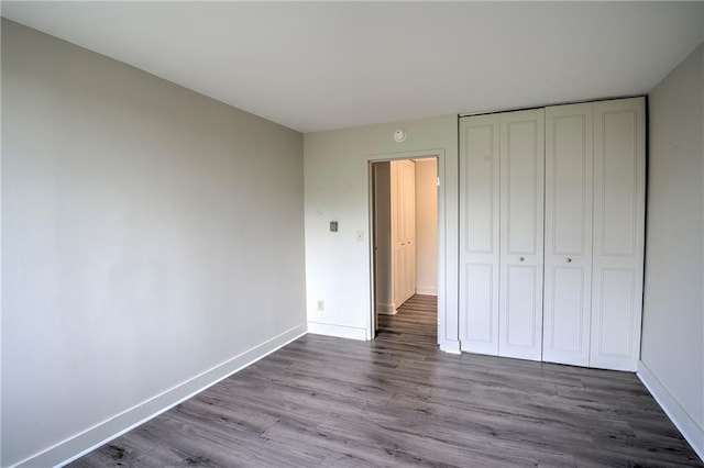 600 E 8th St Unit 5N, Kansas City, MO 64106 - unfurnished bedroom featuring wood finished floors, baseboards, and a closet