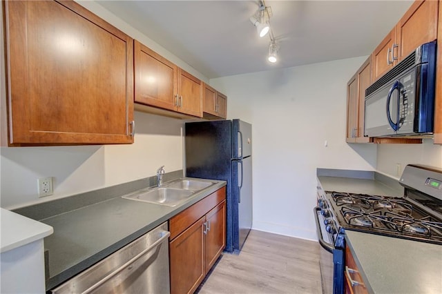600 E 8th St Unit 5N, Kansas City, MO 64106 - kitchen with appliances with stainless steel finishes, a sink, light wood-type flooring, brown cabinetry, and baseboards