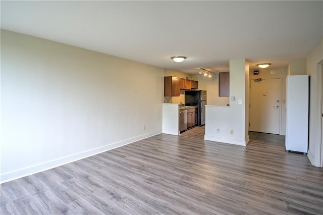 600 E 8th St Unit 5N, Kansas City, MO 64106 - unfurnished living room featuring wood finished floors and baseboards
