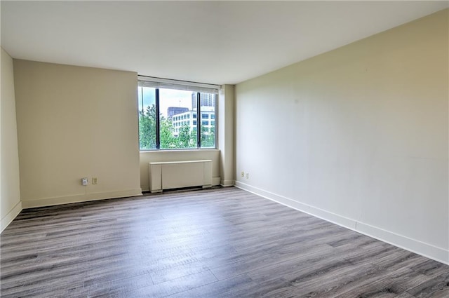 600 E 8th St Unit 5N, Kansas City, MO 64106 - empty room with radiator, wood finished floors, and baseboards