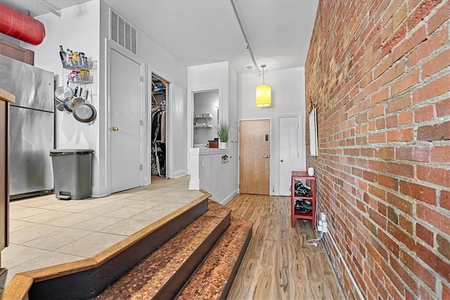 700 Broadway Blvd Unit 507, Kansas City, MO 64105 - foyer featuring brick wall and wood finished floors