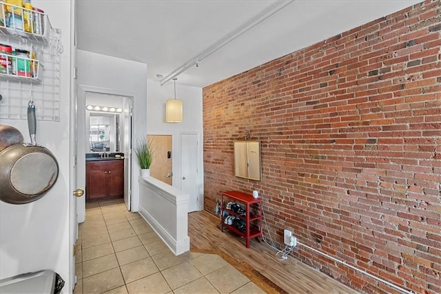 700 Broadway Blvd Unit 507, Kansas City, MO 64105 - laundry area with brick wall, light tile patterned flooring, and rail lighting
