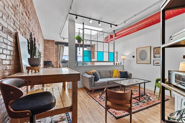 700 Broadway Blvd Unit 507, Kansas City, MO 64105 - living area with wood finished floors, track lighting, and brick wall