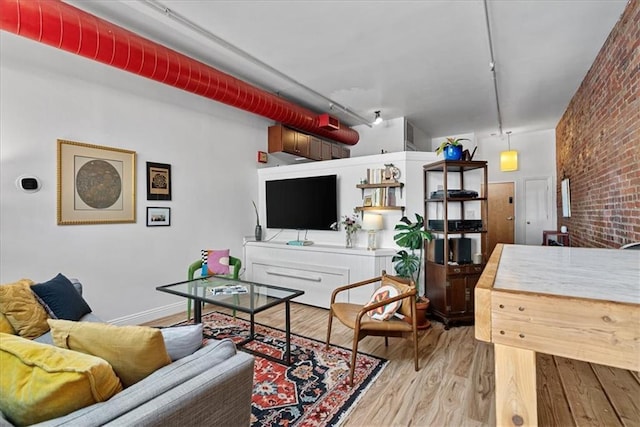 700 Broadway Blvd Unit 507, Kansas City, MO 64105 - living room featuring wood finished floors and brick wall