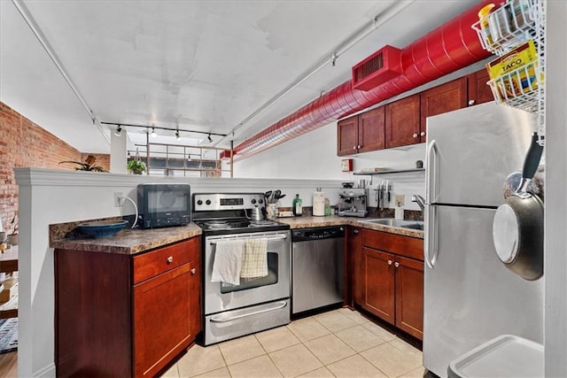 700 Broadway Blvd Unit 507, Kansas City, MO 64105 - kitchen with appliances with stainless steel finishes, light tile patterned floors, rail lighting, and brick wall