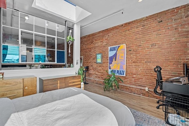 700 Broadway Blvd Unit 507, Kansas City, MO 64105 - bedroom with wood finished floors, brick wall, and a skylight