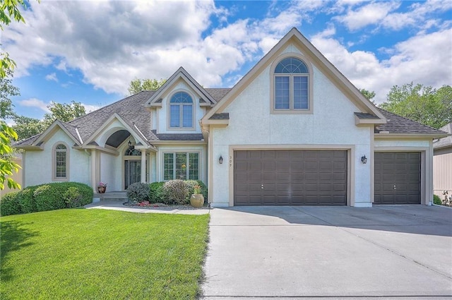 309 E 126th St, Kansas City, MO 64145 - view of front of property with concrete driveway, a front lawn, stucco siding, a garage, and roof with shingles