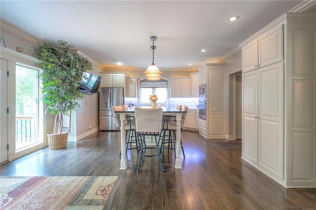 309 E 126th St, Kansas City, MO 64145 - kitchen with appliances with stainless steel finishes, a kitchen bar, dark wood finished floors, pendant lighting, and a kitchen island