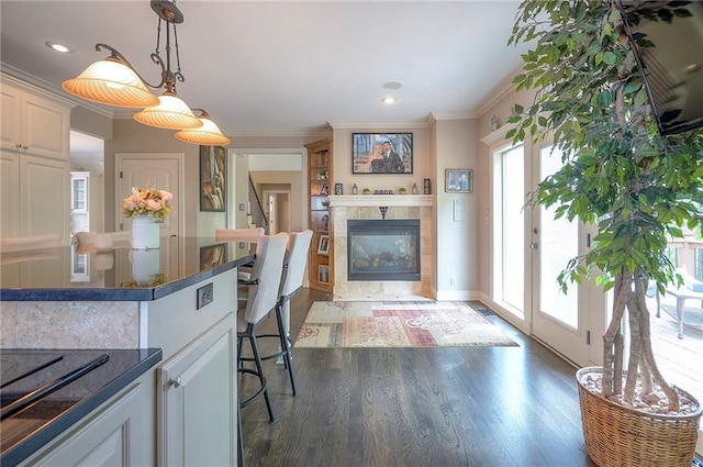 309 E 126th St, Kansas City, MO 64145 - kitchen featuring dark countertops, crown molding, dark wood-style floors, decorative light fixtures, and a fireplace
