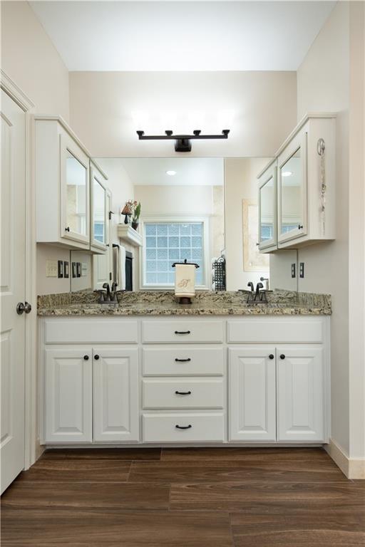 309 E 126th St, Kansas City, MO 64145 - bathroom featuring double vanity and wood finished floors
