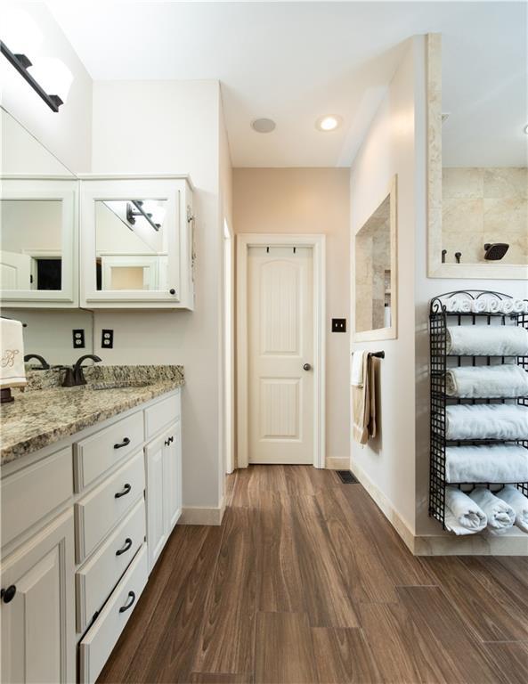 309 E 126th St, Kansas City, MO 64145 - full bathroom with vanity, wood finished floors, and connected bathroom