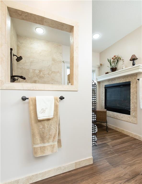 309 E 126th St, Kansas City, MO 64145 - bathroom featuring wood finished floors, a tile fireplace, recessed lighting, and a tile shower