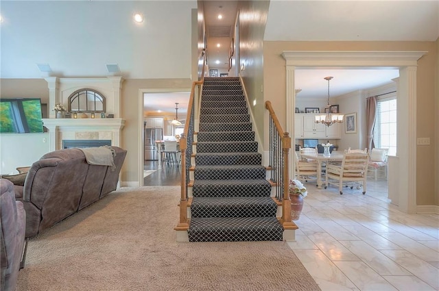 309 E 126th St, Kansas City, MO 64145 - stairs with a chandelier, a tiled fireplace, marble finish flooring, and crown molding