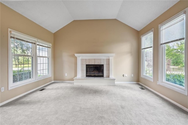 13701 W 149th St, Olathe, KS 66062 - unfurnished living room with carpet floors, plenty of natural light, lofted ceiling, and a tiled fireplace