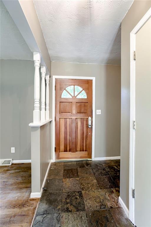 4430 E 107th Ter, Kansas City, MO 64137 - foyer entrance with baseboards and stone finish floors