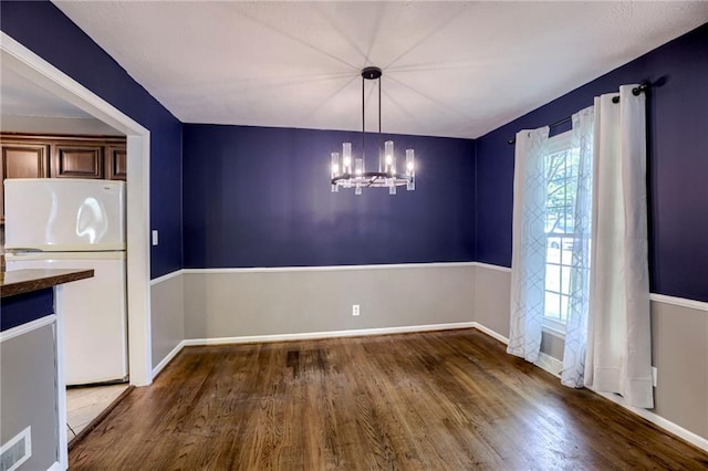 4430 E 107th Ter, Kansas City, MO 64137 - unfurnished dining area featuring wood finished floors and a chandelier