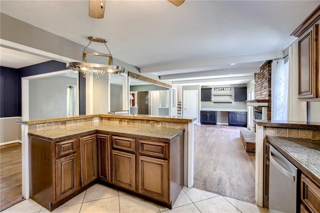 4430 E 107th Ter, Kansas City, MO 64137 - kitchen with stainless steel dishwasher, open floor plan, dark stone counters, and a brick fireplace