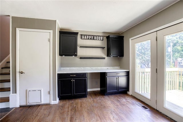 4430 E 107th Ter, Kansas City, MO 64137 - kitchen with wood finished floors, light countertops, and dark cabinetry