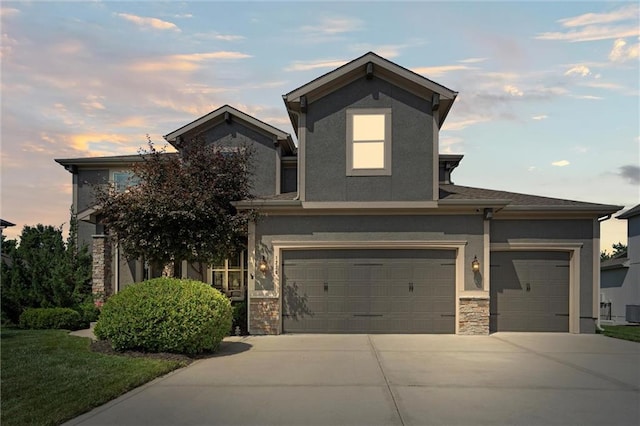 1220 Kingsland Cir, Raymore, MO 64083 - view of front of property featuring concrete driveway, stucco siding, stone siding, and an attached garage