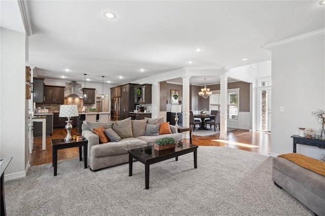 1220 Kingsland Cir, Raymore, MO 64083 - living area with ornate columns, crown molding, wood finished floors, recessed lighting, and a chandelier