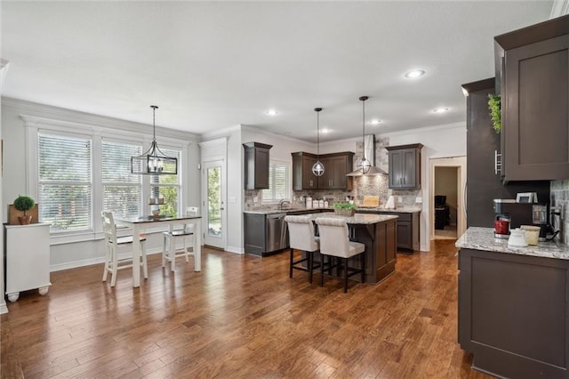 1220 Kingsland Cir, Raymore, MO 64083 - kitchen with wall chimney exhaust hood, a center island, tasteful backsplash, dishwasher, and crown molding