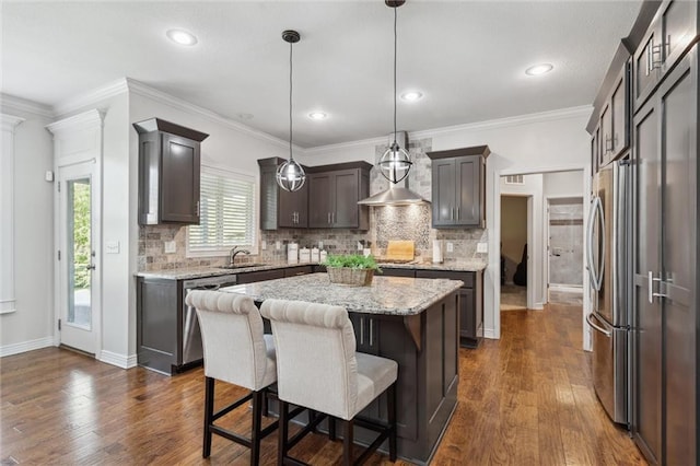1220 Kingsland Cir, Raymore, MO 64083 - kitchen with a center island, stainless steel appliances, decorative backsplash, dark wood-style flooring, and recessed lighting