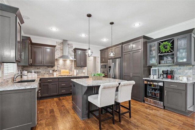 1220 Kingsland Cir, Raymore, MO 64083 - kitchen featuring wall chimney exhaust hood, wine cooler, stainless steel appliances, crown molding, and tasteful backsplash
