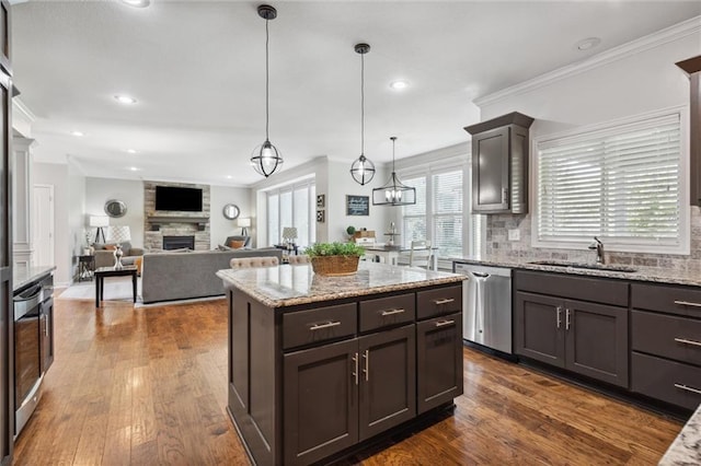 1220 Kingsland Cir, Raymore, MO 64083 - kitchen featuring stainless steel dishwasher, a fireplace, backsplash, dark brown cabinetry, and crown molding